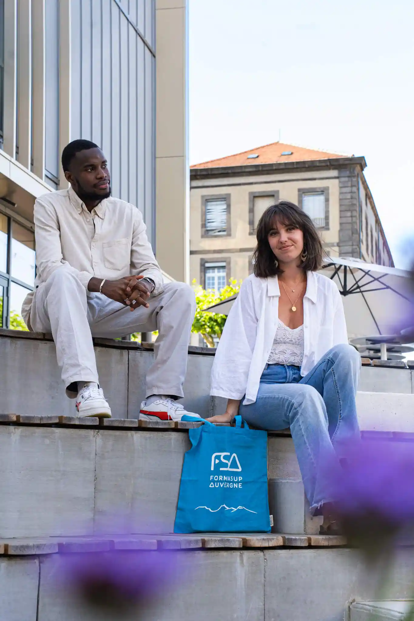 Deux jeunes assis sur des marches à l’extérieur